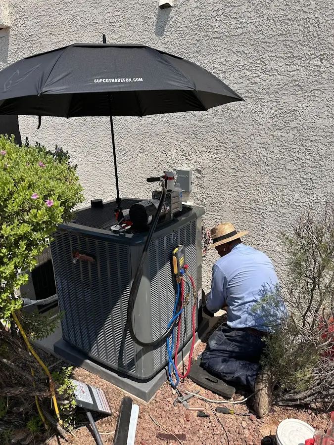 HVAC technician performing outdoor AC maintenance in Danvers
